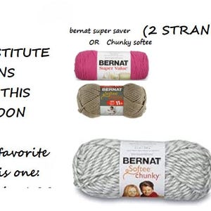 May include: Three balls of yarn, one pink, one brown, and one grey and white. The pink ball is labelled "Bernat Super Value", the brown ball is labelled "Bernat Softee", and the grey and white ball is labelled "Bernat Softee Chunky". The text "Substitute Yarns for this Cocoon (My favourite is this one)" is written above the balls. The text "bernat super saver (2 STRANDS) OR Chunky softee" is written above the pink ball.