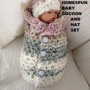 May include: A crocheted baby cocoon and hat set in pink, beige, and grey. The cocoon has buttons down the front and the hat has a pompom on top.