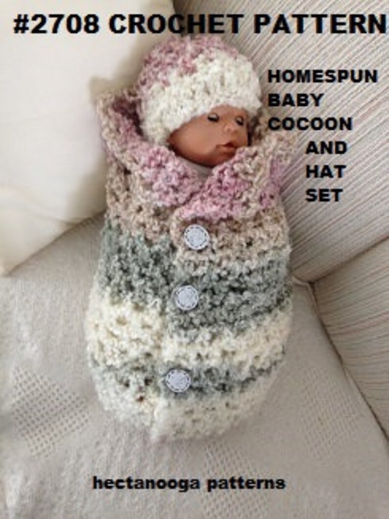 May include: A crocheted baby cocoon and hat set in pink, beige, and grey. The cocoon has buttons down the front and the hat has a pompom on top.