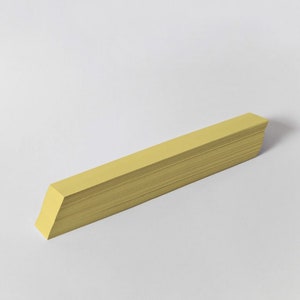 May include: A stack of yellow paper strips, likely for crafts or scrapbooking.