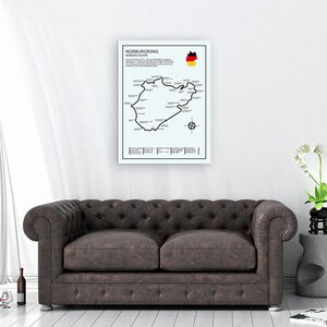 May include: A black and white poster featuring a map of the N&uuml;rburgring Nordschleife race track. The poster also includes the German flag and the text "N&uuml;rburgring Nordschleife".