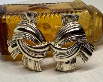 Pendientes de clip con nudo en tono oro pálido vintage firmados por Kramer; Pendientes de clip gruesos firmados por el diseñador.