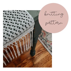 May include: A white crocheted table runner with fringe on a dark green table. The text "knitting pattern" is written in a circle on a pink background.