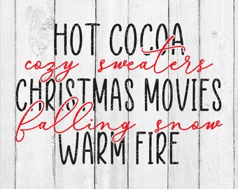 May include: Black and red text on a white wood background. The text reads "HOT COCOA cozy sweaters CHRISTMAS MOVIES falling snow WARM FIRE".