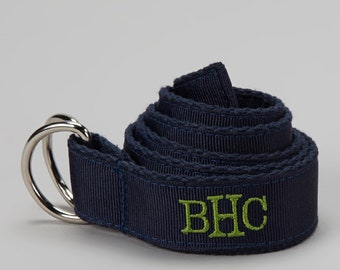 May include: A navy blue woven belt with a silver double-ring buckle. The belt has the initials "BHC" embroidered in green.