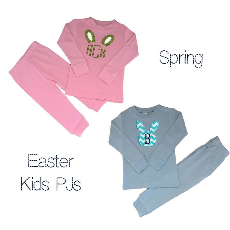 May include: Two sets of children's pajamas. One set is pink with green bunny ears and the letters "ACK". The other set is light blue with a chevron bunny design and the letter "B". The text "Easter Kids PJs" and "Spring" are also visible.