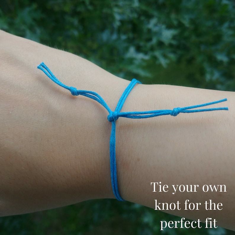 This shows an example on how you tie the bracelet on your wrist. You tie your own knot for the perfect fit. You can then cut any excess cord. The cord in this example is turquoise.
