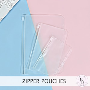 May include: Three clear plastic zipper pouches with holes for a binder. The pouches are arranged in descending size order, with the largest pouch on the left and the smallest pouch on the right. The pouches are on a blue and pink background.