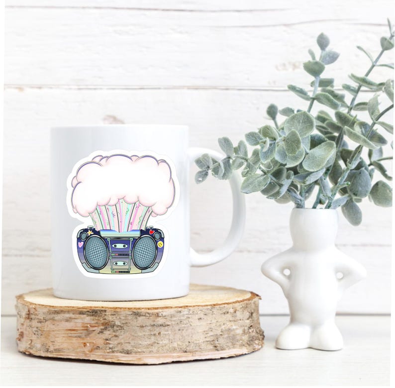 May include: White ceramic mug with a colorful graphic of a boombox with a pink cloud exploding from it. The graphic has a retro style.