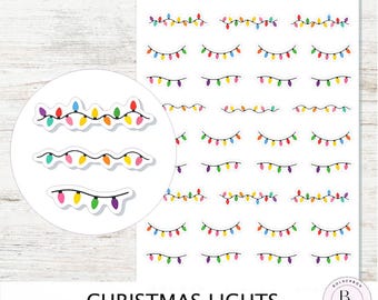 Puede incluir: Hoja de pegatinas de luces navideñas con bombillas de colores. La hoja incluye múltiples hileras de luces en diferentes diseños, con un primer plano de tres hileras de luces en un círculo blanco. El texto "Christmas Lights" está en la parte inferior.