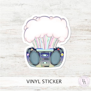May include: A vinyl sticker featuring a cartoon boombox with a pink and blue cloud bursting out of the top. The cloud is filled with colorful confetti and the boombox has a blue and black design.