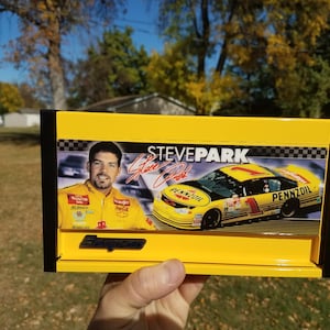 May include: Yellow metal toolbox with a black border. The front of the toolbox features a photo of a race car driver, Steve Park, and his race car. The car is yellow and black with the Pennzoil logo. The toolbox also has a Snap-on logo.