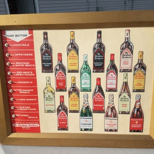May include: Vintage framed advertisement for The Christian Brothers Brandy, featuring illustrations of various liquor bottles. The gold-colored frame surrounds a cream-colored background with text and bottle images.