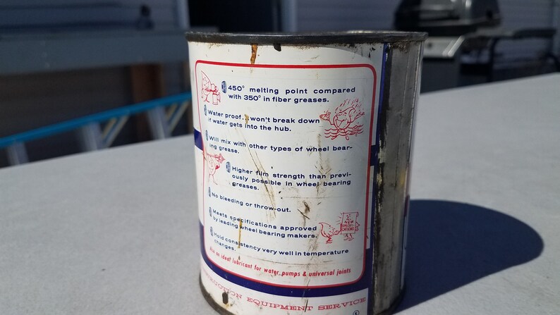 May include: A white metal can with red and blue text and illustrations. The text reads "450&deg; melting point compared with 350&deg; in fibre greases. Water proof - won't break down if water gets into the hub. Will mix with other types of wheel bearing grease. Higher film strength than previously possible in wheel bearing greases. No bleeding or throw-out. Meets specifications approved by leading wheel bearing makers. Good consistency very well in temperature changes. An ideal lubricant for water pumps & universal joints. DON EQUIPMENT SERVICE"