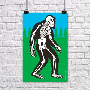 May include: A poster featuring a Bigfoot illustration with a skeleton overlay. The artwork depicts the creature in black fur with a white skeletal structure, set against a green field, blue sky, and stylized trees. The poster is hanging on a white brick wall.