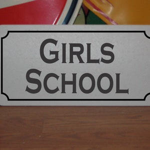 Insegna in metallo della scuola femminile