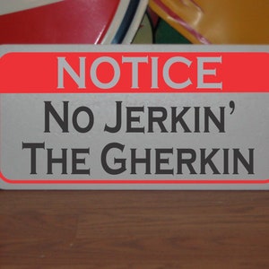 Puede incluir: Un letrero blanco con borde rojo y el texto "NOTICE No Jerkin' The Gherkin" en negro.