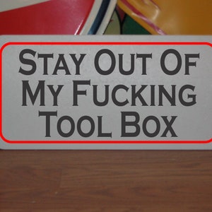 Puede incluir: Un letrero blanco con borde rojo, que dice "STAY OUT OF MY FUCKING TOOL BOX".