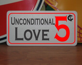 May include: A white sign with a red border and red text that reads "Unconditional Love 5¢".