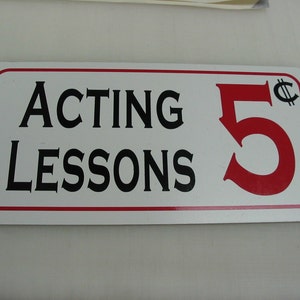 Może przedstawiać: Biały prostokątny znak z czerwoną obwódką. Znak zawiera czarny tekst "Acting Lessons" i czerwoną cyfrę "5" z symbolem centa.