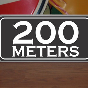 May include: A black and white sign with the text "200 METERS" in white lettering.
