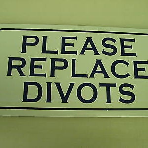Puede incluir: Un letrero blanco con borde negro y texto azul que dice "Por favor, reemplace los divots".