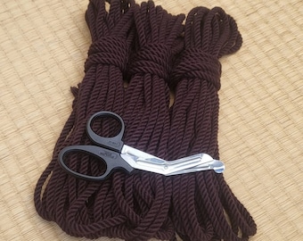 May include: Three spools of dark brown rope with a pair of black handled scissors on top.