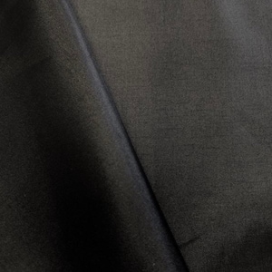 May include: Black satin fabric with a smooth, silky texture. The fabric is folded in half, showing the front and back sides.
