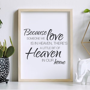 Può includere: Una stampa incorniciata con sfondo bianco e testo nero che recita "Because love someone we is in heaven, there's a little bit of heaven in our home".