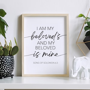 May include: A framed print with a white background and black text that reads "I am my beloved's and my beloved is mine" with the scripture reference "Song of Solomon 6:3" below the text.