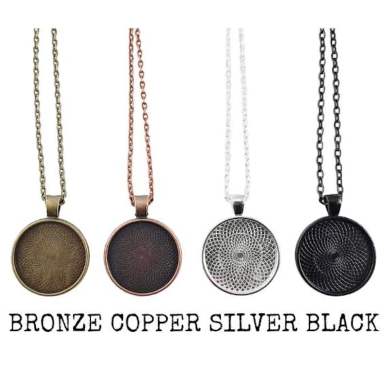 Puede incluir: Cuatro collares con colgantes en bronce, cobre, plata y negro. Cada collar tiene un colgante redondo con un dise&ntilde;o detallado y una cadena a juego. El texto "BRONZE COPPER SILVER BLACK" est&aacute; en la parte inferior.