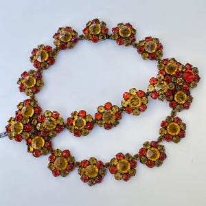Ensemble collier ras-de-cou et bracelet vintage Schreiner, en strass ambre inversé, orange et jaune, à maillons en forme de fleur, vendu en l'état pour réparation.