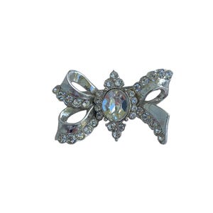 Spilla con fiocco in pasta di cristallo e strass color argento firmata VTG Coro