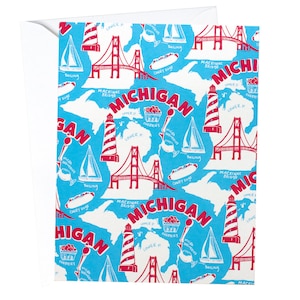 以下が含まれることがあります： マッキナック橋、灯台、サクランボ、そして「ミシガン」と「MICHIGAN」の文字が赤で描かれた青と白のパターンの包装紙です。