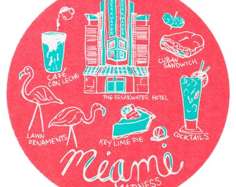 Puede incluir: Un posavasos redondo ilustrado en rosa y blanco con las palabras "Miami Madness" en una fuente estilizada. El posavasos presenta varias ilustraciones de artículos con temática de Miami, que incluyen un hotel, una tarta de lima, un sándwich cubano, un vaso de café con leche, un cóctel y flamencos.