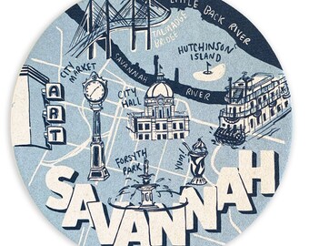 May include: A blue and white illustrated map of Savannah, Georgia. The map features landmarks like City Market, City Hall, Forsyth Park, and the Talmadge Bridge. The text "SAVANNAH" is written in large, bold letters across the bottom of the map.