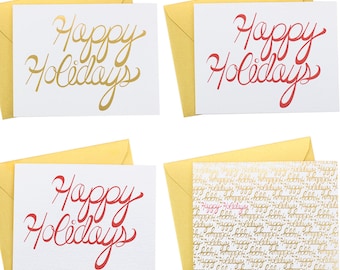 Può includere: Quattro carte bianche con scritte dorate e rosse. Le carte hanno il testo "Happy Holidays" scritto in una varietà di caratteri corsivi. Le carte sono visualizzate su uno sfondo giallo.
