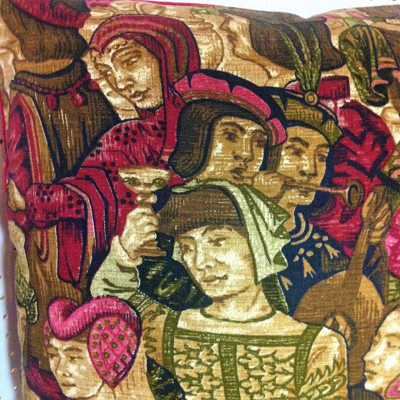 May include: A colorful tapestry pillow featuring a medieval scene with figures in red, gold, and green clothing. The figures are playing musical instruments and appear to be in a festive setting.
