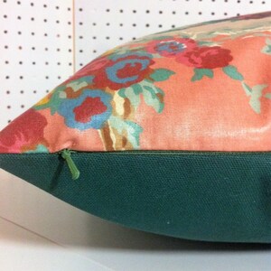 May include: A pink pillow with a floral pattern and a green zipper. The pillow is made of a soft, comfortable fabric and has a hidden zipper closure.