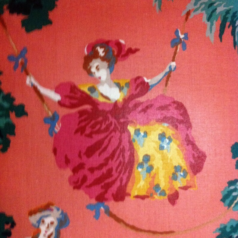 May include: A vintage wallpaper design featuring a woman in a pink and yellow dress swinging on a rope. The background is a solid pink color with green foliage.