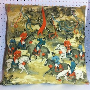 Könnte beinhalten: Quadratisches Kissen mit einem Vintage-Druck im asiatischen Stil. Das Design zeigt Figuren auf Pferden in roter und blauer Kleidung, vor einer Landschaft mit Fahnen und Bändern. Die Farbpalette umfasst Beige-, Grau- und Rottöne.