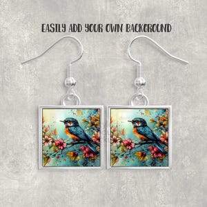 Pu&ograve; includere: Un paio di orecchini quadrati con un dipinto ad acquerello di un uccello blu e arancione posato su un ramo fiorito. Gli orecchini hanno ganci e montature color argento. Il testo "EASILY ADD YOUR OWN BACKGROUND" &egrave; sopra.
