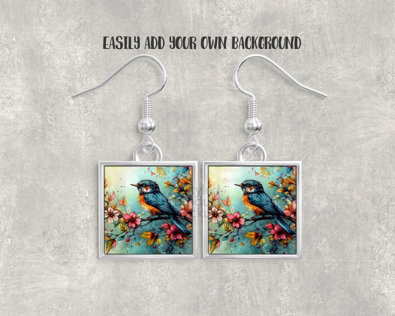 Pu&ograve; includere: Un paio di orecchini quadrati con un dipinto ad acquerello di un uccello blu e arancione posato su un ramo fiorito. Gli orecchini hanno ganci e montature color argento. Il testo "EASILY ADD YOUR OWN BACKGROUND" &egrave; sopra.