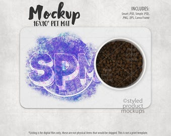 May include: A white 16x10 inch pet mat with a purple and blue watercolor design. The mat has a white bowl filled with brown dog food on top of it. The text "SPM" is in the center of the mat.