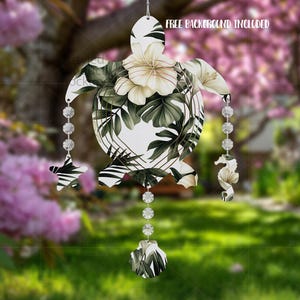 Op de afbeelding: Een decoratief, wit zeeschildpadornament met een bloemen- en bladerpatroon in groen- en wittinten. Het ornament heeft een reeks heldere, facetgeslepen kralen en decoratieve bedels. De tekst "FREE BACKGROUND INCLUDED" is zichtbaar.