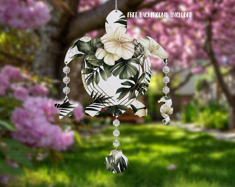 Op de afbeelding: Een decoratief, wit zeeschildpadornament met een bloemen- en bladerpatroon in groen- en wittinten. Het ornament heeft een reeks heldere, facetgeslepen kralen en decoratieve bedels. De tekst "FREE BACKGROUND INCLUDED" is zichtbaar.