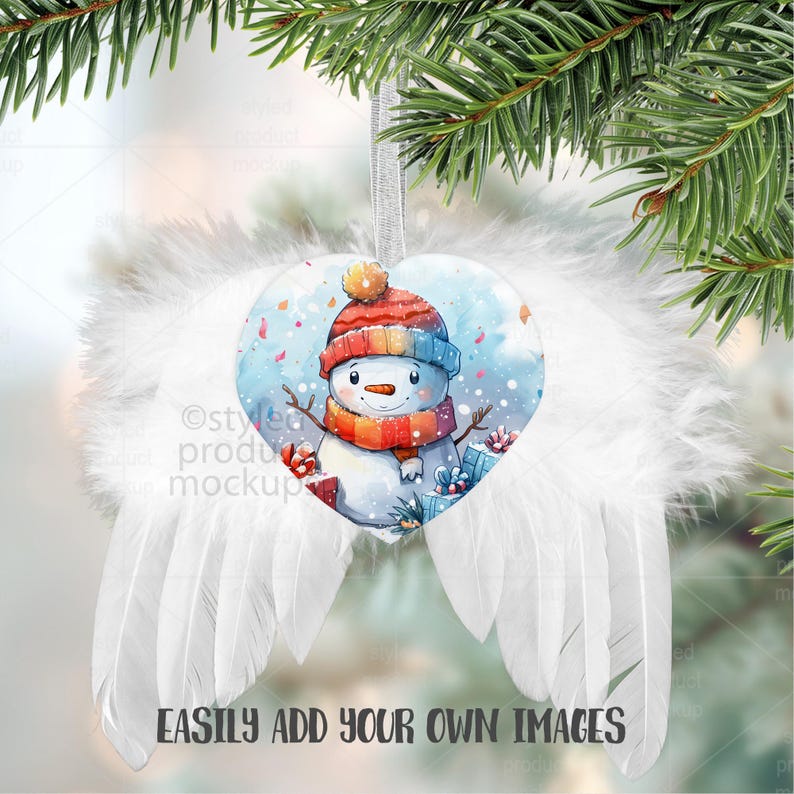 May include: A heart-shaped Christmas ornament featuring a watercolor snowman wearing a red and blue hat and scarf. The ornament is surrounded by white feather wings and hangs from a silver ribbon. The text "EASILY ADD YOUR OWN IMAGES" is at the bottom.