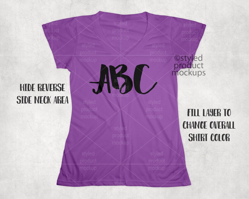 Op de afbeelding: Een paars V-hals T-shirt met het woord "ABC" in zwart script over de voorkant. Het shirt is effen van kleur en heeft korte mouwen. Tekst op de afbeelding is "HIDE REVERSE SIDE NECK AREA" en "FILL LAYER TO CHANGE OVERALL SHIRT COLOR."