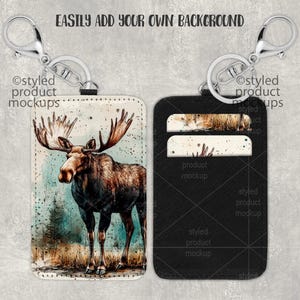 May include: A black leather keychain with a moose illustration on one side and two card slots on the other side. The keychain is attached to a silver split ring.