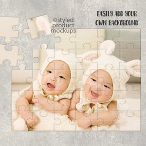 May include: Two babies wearing white bunny costumes are lying on a white blanket. The babies are smiling and looking at the camera. The image is a jigsaw puzzle with some pieces missing.